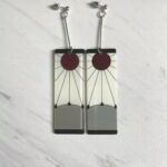 A pair of earrings with a red and white design.