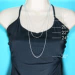 A mannequin mannequin wearing a silver chain necklace.