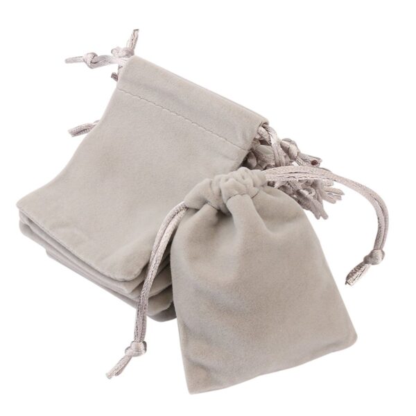 A set of grey velvet pouches on a white background.