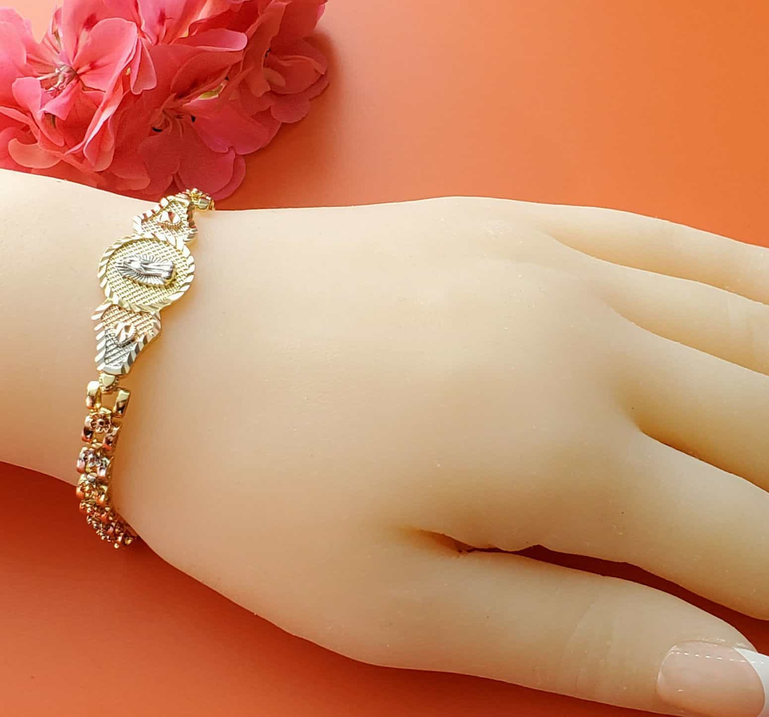 A woman’s hand with a gold bracelet on it.