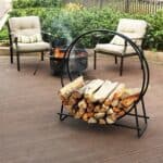 A firewood rack on a deck with chairs.