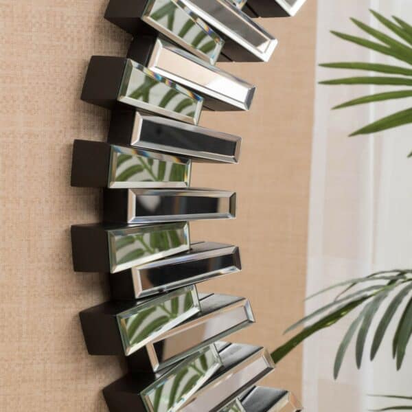 A mirror with a spiral design on the wall.