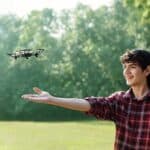 A young boy flies a remote controlled drone.