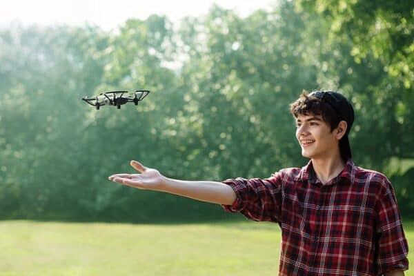 A young boy flies a remote controlled drone.