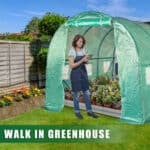 A woman standing in a greenhouse.