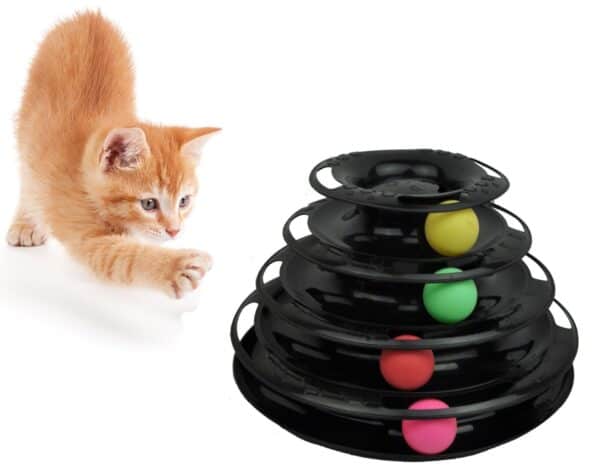 A cat running towards a black object with colorful balls.