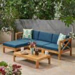 A teak sectional sofa set with blue cushions and a coffee table.