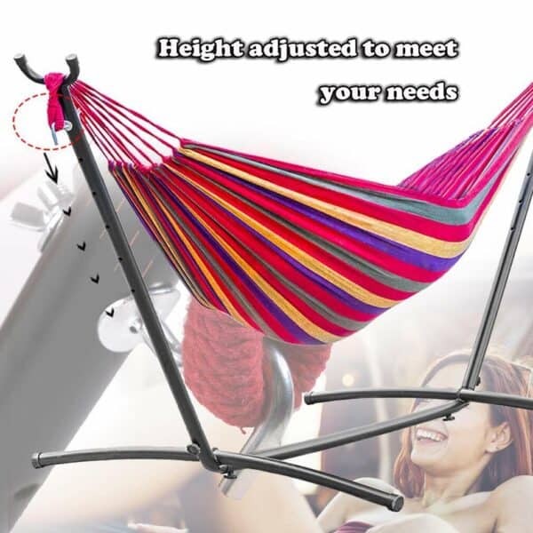 A woman is sitting in a hammock on a stand.
