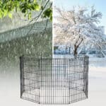 A picture of a snow covered dog kennel with a tree in the background.