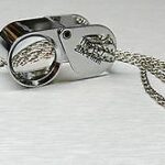 A silver cuff with a chain attached to it.