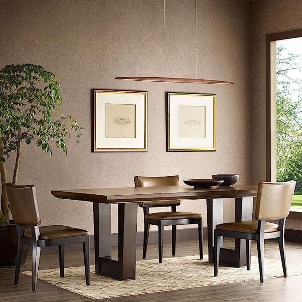 A modern dining room featuring a wooden table, four chairs, and two framed artworks on the wall, accompanied by a potted tree and the 39"Wood Linear Pendant Light LED Dimmable Hanging Light Fixture Wood Linear Light Island Lights 24w Walnut.