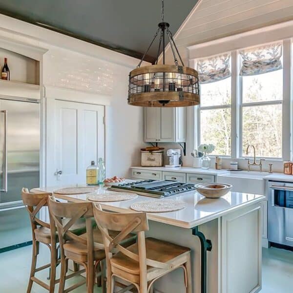 Bright kitchen with a central island, wooden stools, and large windows overlooking nature, featuring a stylish Farmhouse Rustic Chandelier Light Fixture 4-Light Round Hanging Pendant Lighting Black Wood and Black Metal Finish.
