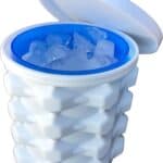 An open white, textured portable ice bucket filled with ice cubes from The Ultimate Mini Ice Cube Maker Pink Silicone Bucket Ice Mold and Storage Bin, featuring a blue interior and matching white lid lifted off to the side.