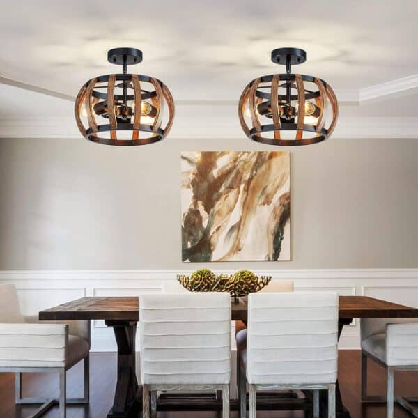 Two Modern Semi Flush Mount Ceiling Light Crystal Ceiling Lights with 12 Inch Round Metal and Crystal Shades Matte Black hang above a wooden dining table with six white chairs in a neutrally decorated room with an abstract painting on the wall.