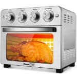 A Geek Chef Toaster Oven 6 Slice 24QT Convection Air fryer 1700W with a whole roasted chicken inside, visible through the glass door.