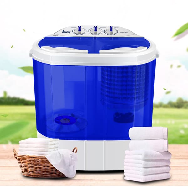 A portable ZOKOP 10.4Lbs semi-automatic twin-tub washing machine with dials on top, placed beside a basket of white towels, set against a blurred outdoor background.